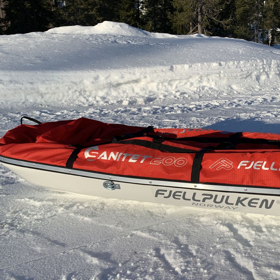 Redningspulk med rødt sanitetstrekk på snø